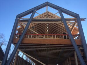 Installation of steel I-beam moment frame to provide structural support for home due to extensive use of glass and windows.